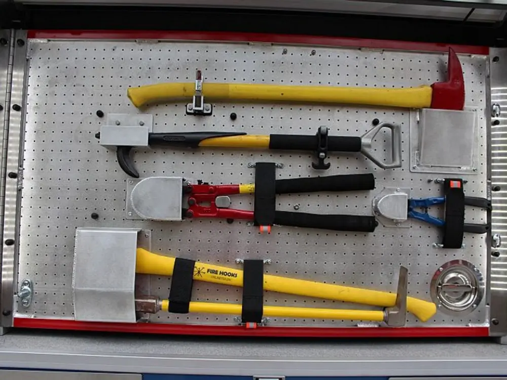 Exterior view of small fire truck showing cab, body compartments, and wheel/tire area.