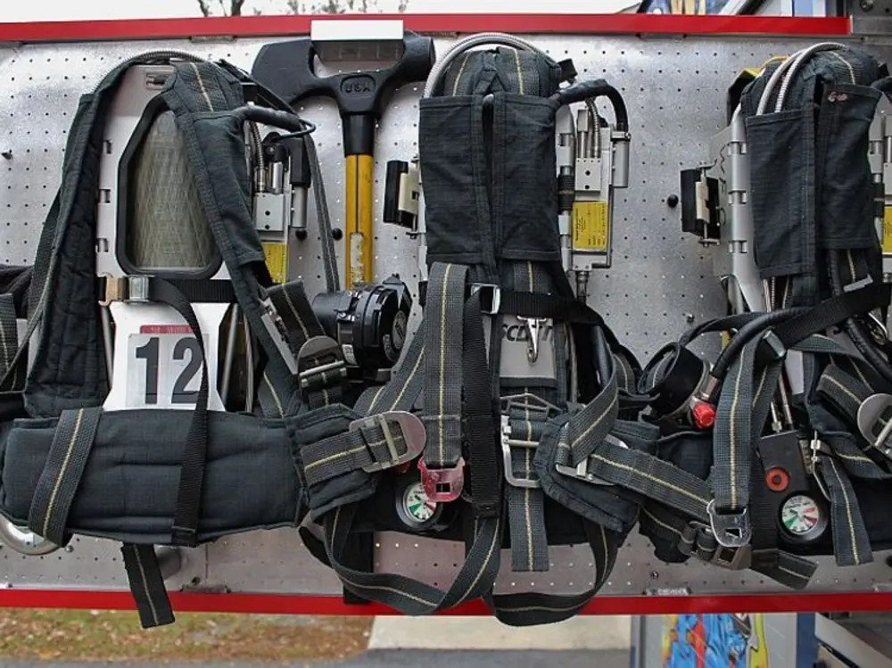 Exterior view of small fire truck showing cab, body compartments, and wheel/tire area.