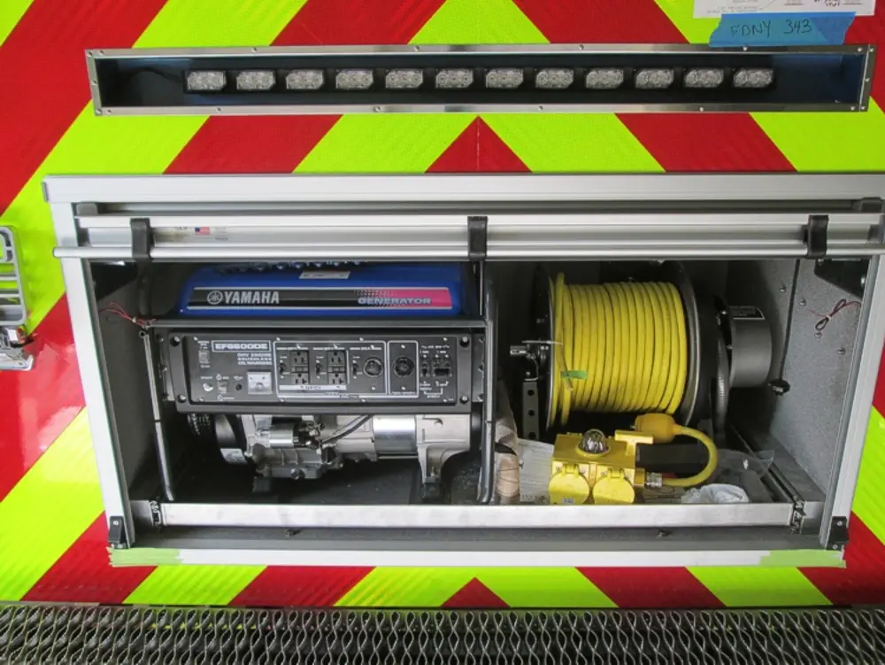 Exterior view of small fire truck showing cab, body compartments, and wheel/tire area.