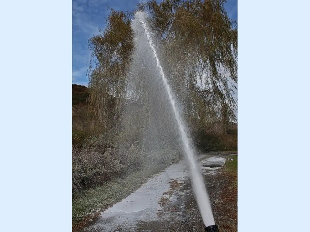 Exterior view of small fire truck showing cab, body compartments, and wheel/tire area.