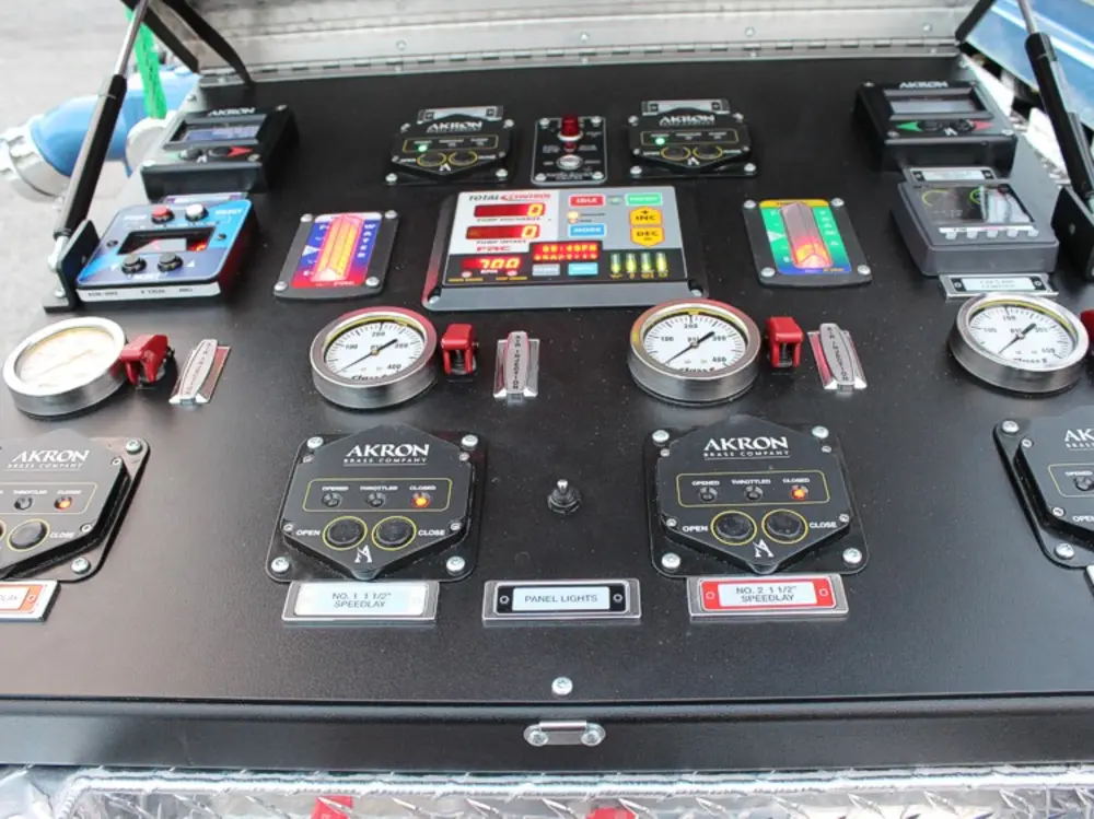 Exterior view of small fire truck showing cab, body compartments, and wheel/tire area.