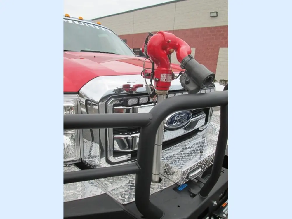 Exterior view of small fire truck showing cab, body compartments, and wheel/tire area.