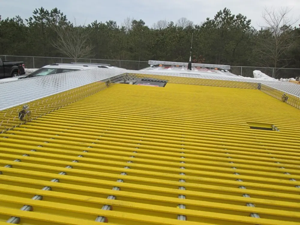 Exterior view of small fire truck showing cab, body compartments, and wheel/tire area.