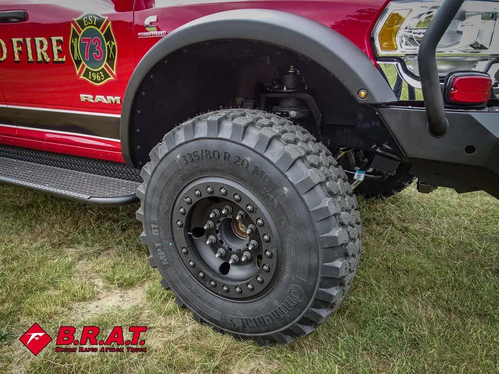 Front wheel and fender close-up showing off-road tire and suspension clearance.