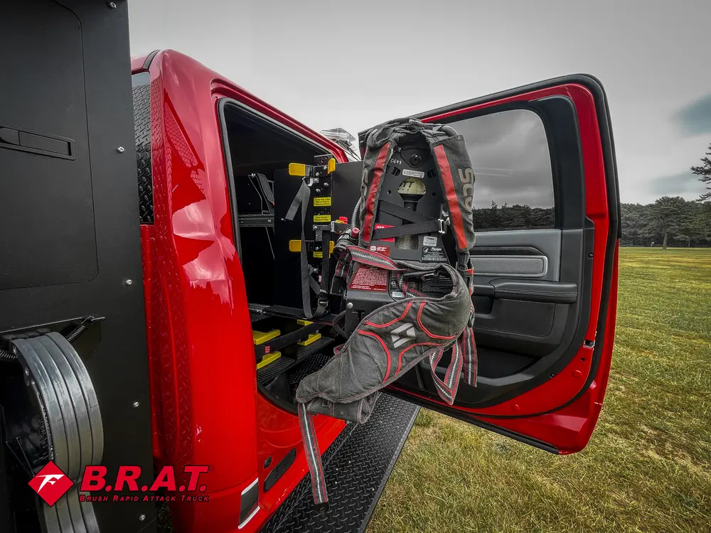 Open rear cab door view with mounted tool rack and seatback equipment.