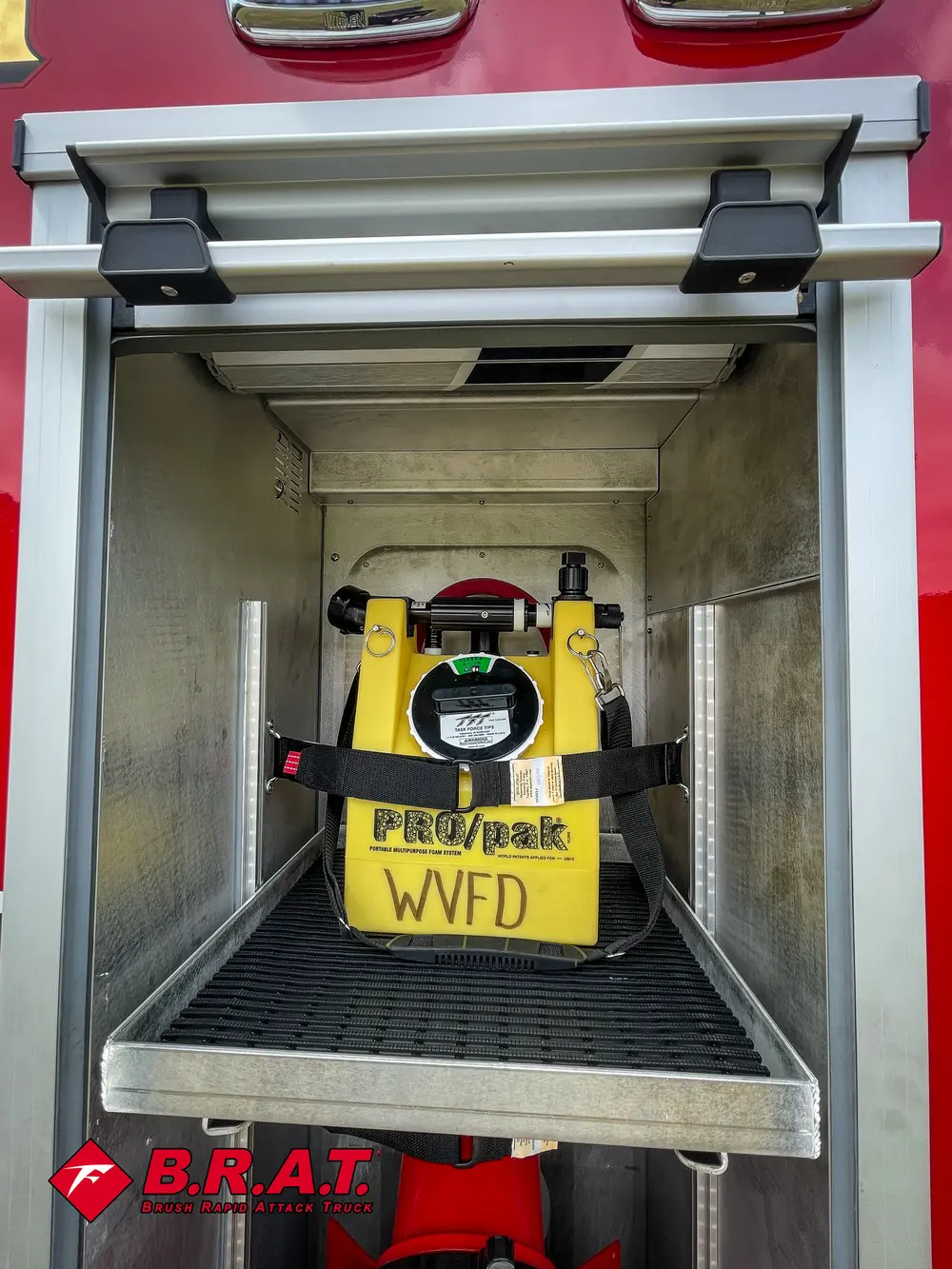 Compartment close-up centered on yellow power unit and red nozzle mount.
