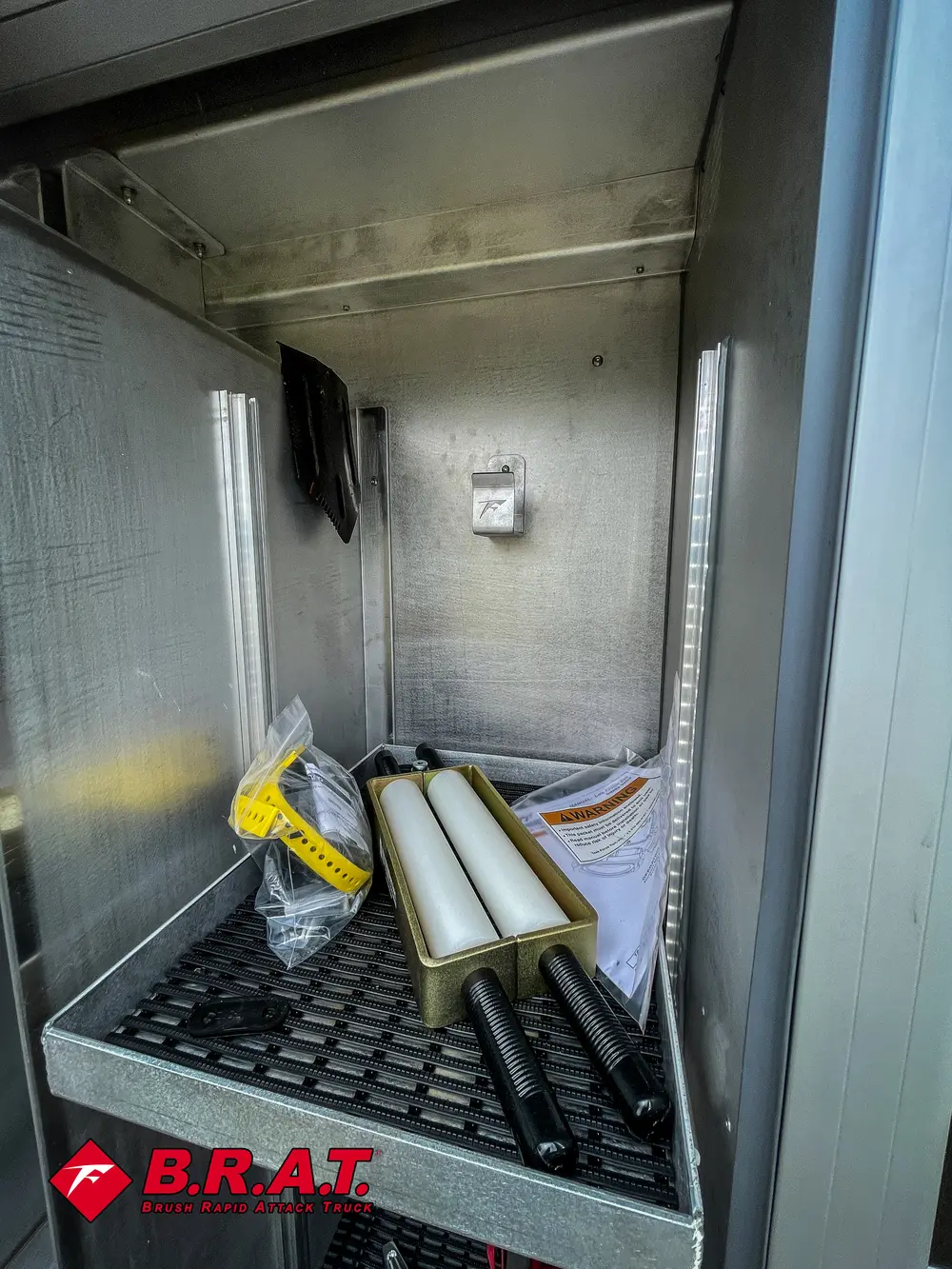 Narrow vertical compartment with small loose items on the floor.