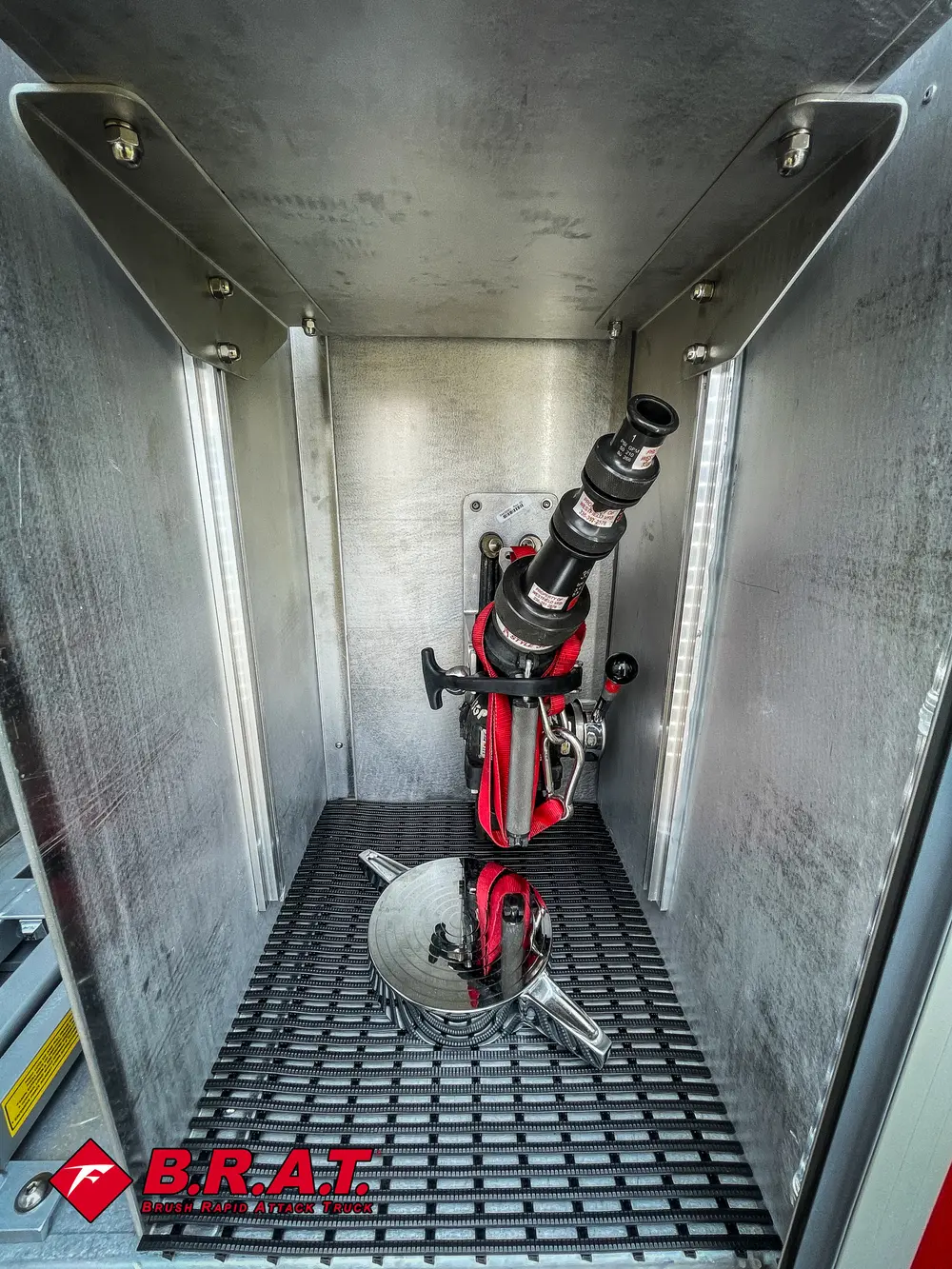 Vertical compartment with mounted red nozzle or lance tool.