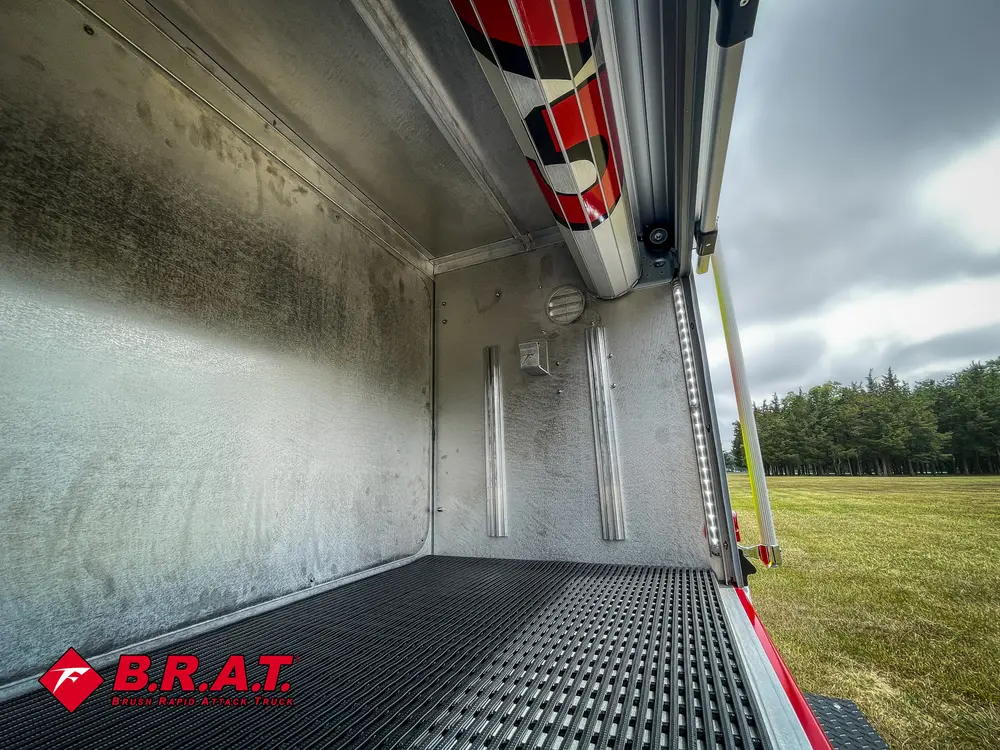 Inside rear compartment showing metal wall, lighting, and floor tracks.
