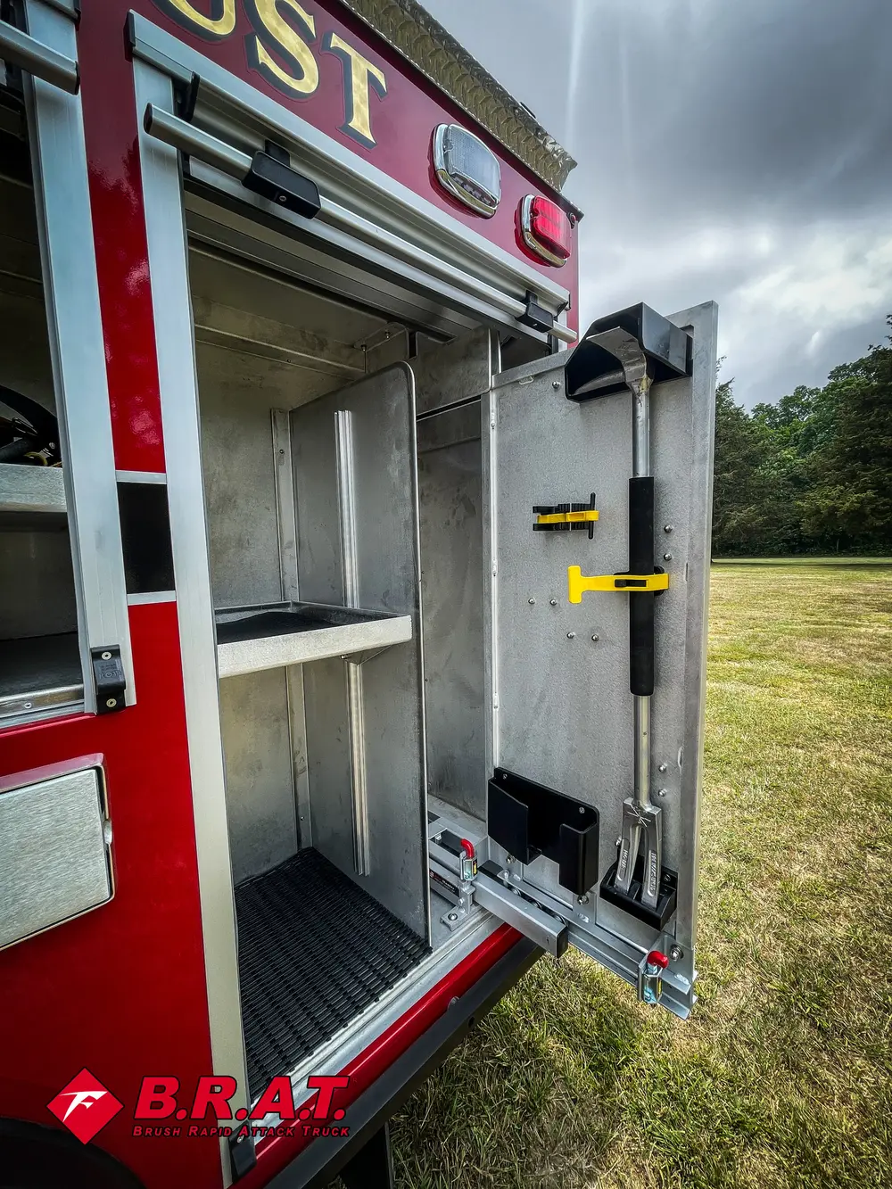 Vertical side compartment with mounted yellow-handled tools and shelving.