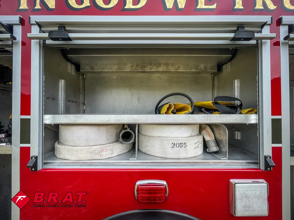 Open side compartment with hose bundle and shelf storage.