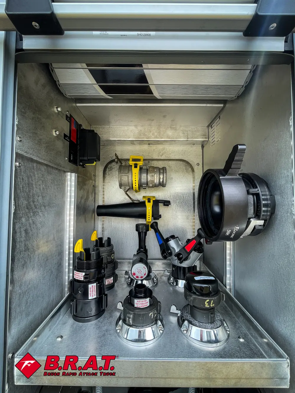 Vertical compartment close-up with mounted nozzles and hand tools.