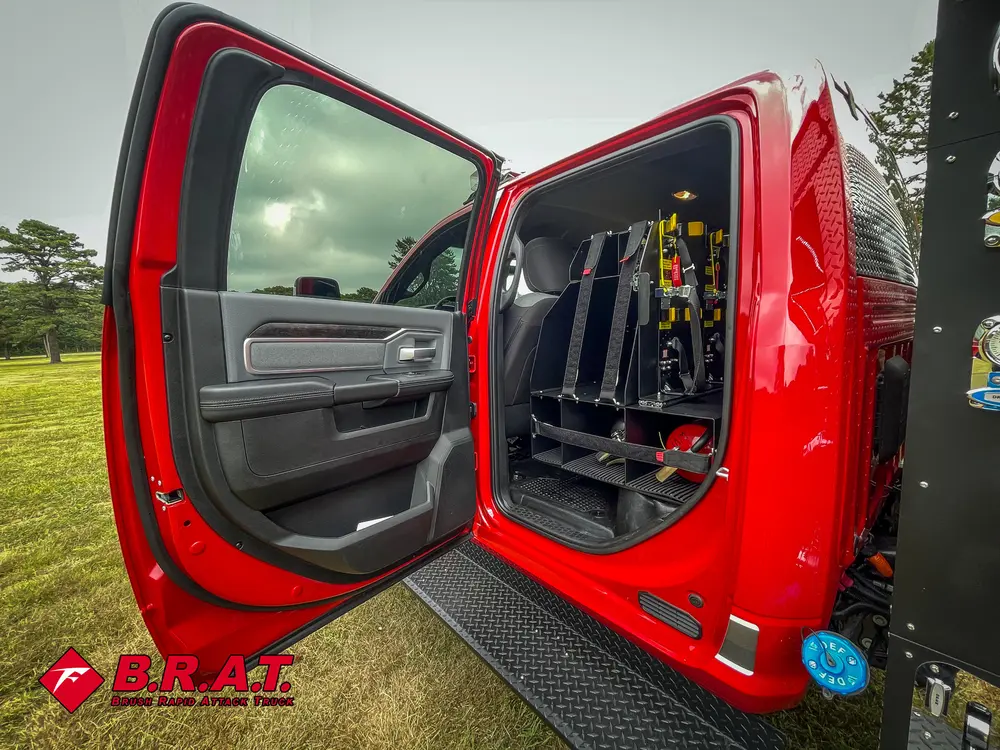 Open rear cab door with mounted tool rack and rear seat visible.