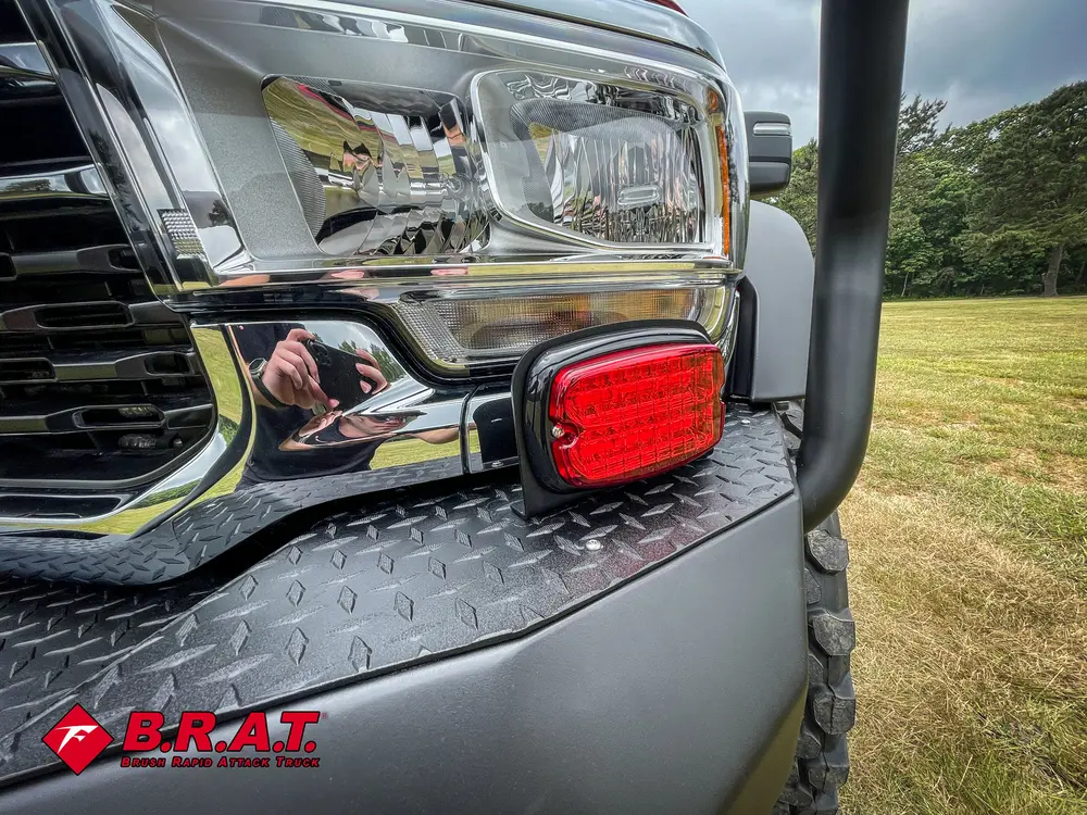 Headlight and bumper corner close-up with red marker light.