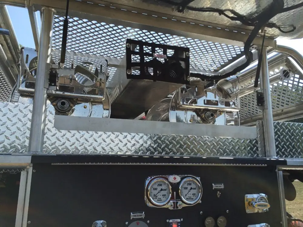 Exterior view of small fire truck showing cab, body compartments, and wheel/tire area.