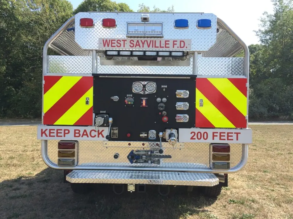 Exterior view of small fire truck showing cab, body compartments, and wheel/tire area.