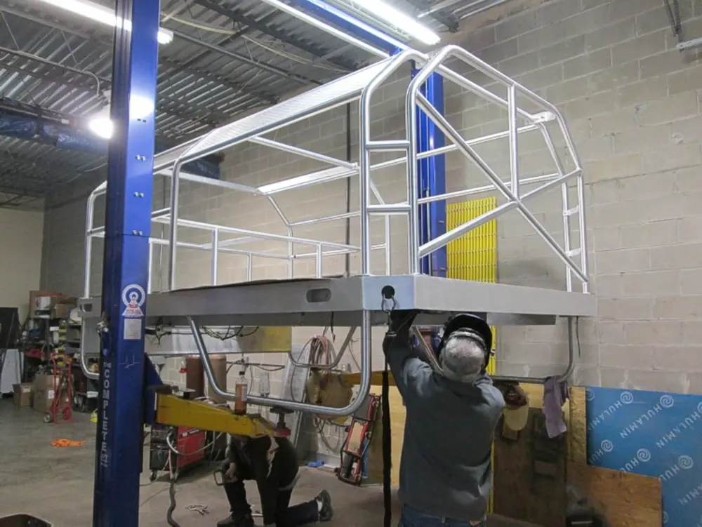 Exterior view of small fire truck showing cab, body compartments, and wheel/tire area.