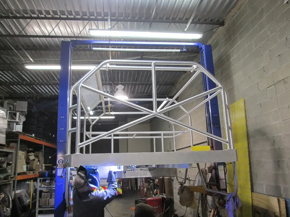 Exterior view of small fire truck showing cab, body compartments, and wheel/tire area.