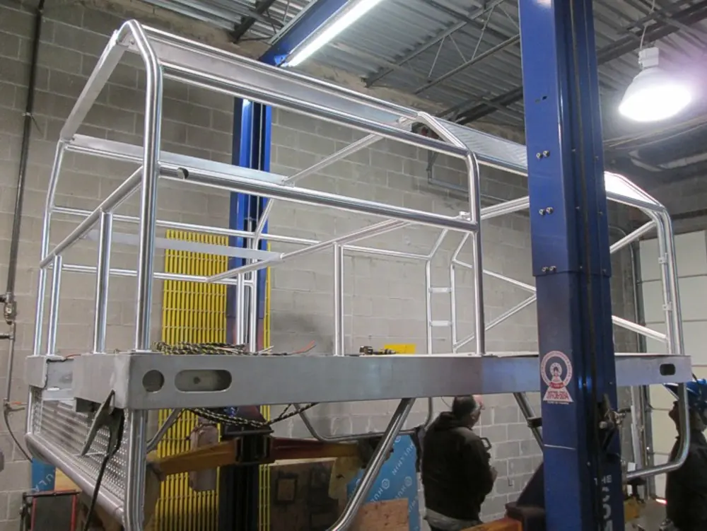 Exterior view of small fire truck showing cab, body compartments, and wheel/tire area.