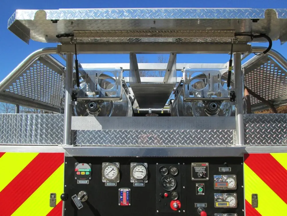 Exterior view of small fire truck showing cab, body compartments, and wheel/tire area.