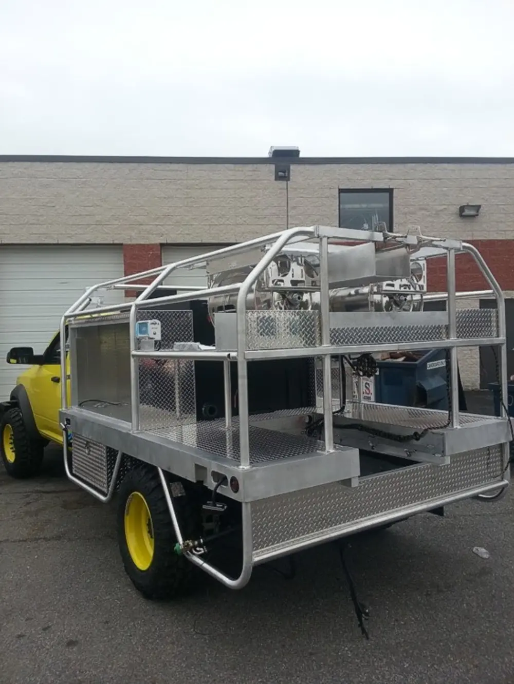 Exterior view of small fire truck showing cab, body compartments, and wheel/tire area.