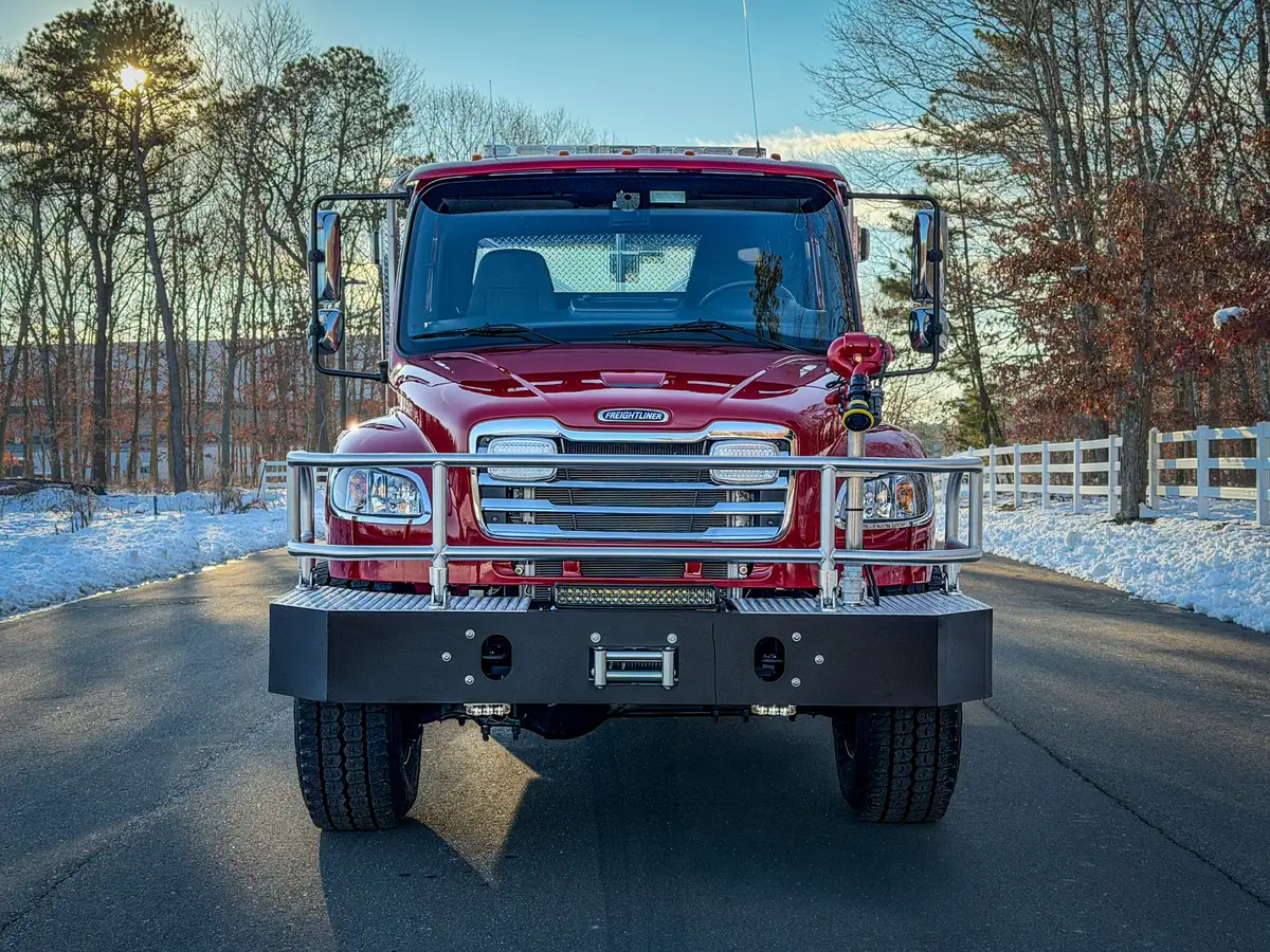 Head-on front exterior view showing grille guard, front bumper winch, and bumper-mounted monitor.