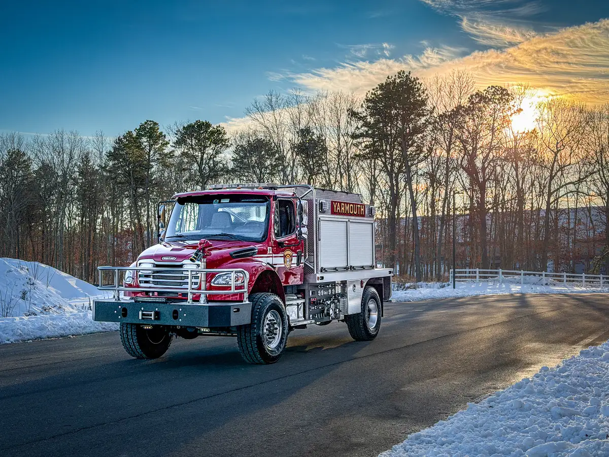 Front-left three-quarter exterior view with side body, pump-panel area, and rear wheel visible.