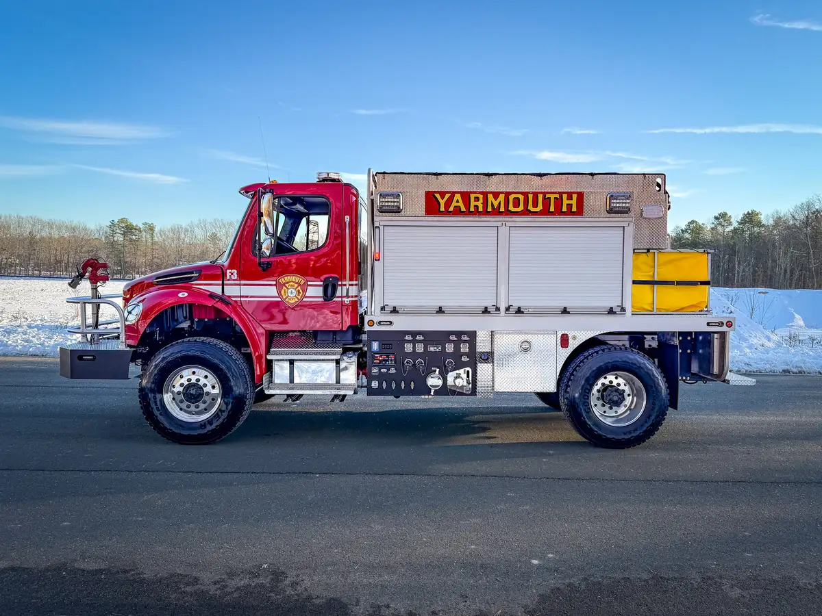 Left side profile showing upper roll-up compartments, pump panel, and rear foldable dump tank.