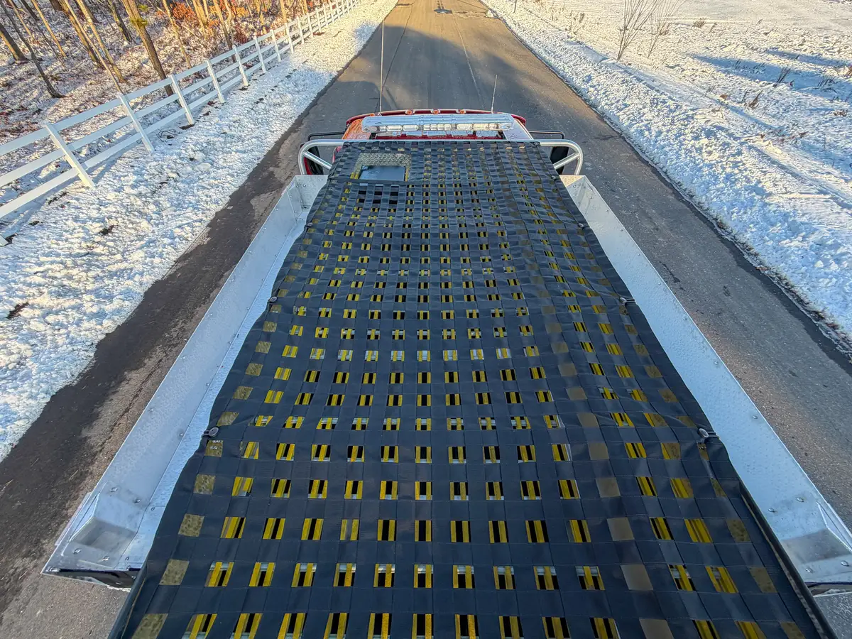 Top-down view of hosebed safety net over yellow hose lines.