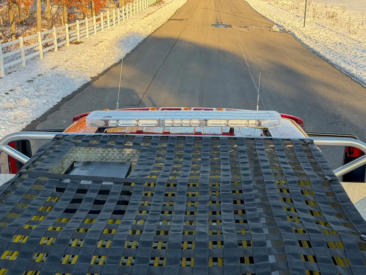 Top-front view over hosebed net toward the cab roof lightbar.