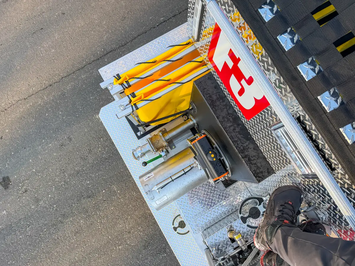 Top-down rear equipment view with folded dump tank and dump chute components.