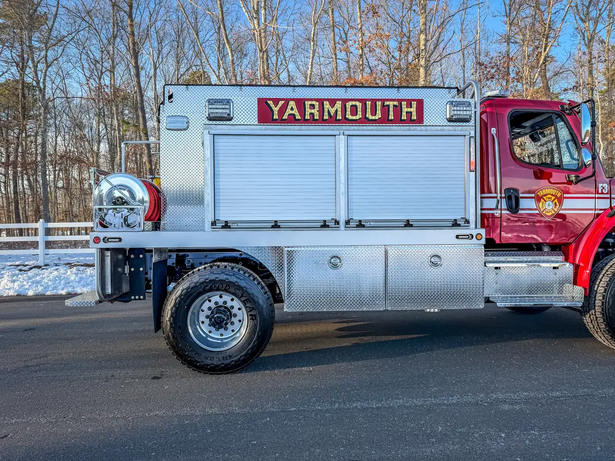 Right side profile with compartments closed and rear hose reel visible.