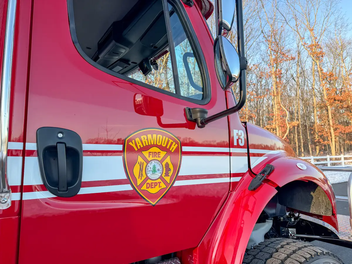 Close-up of cab door area with mirror, front fender, and door-side marking.