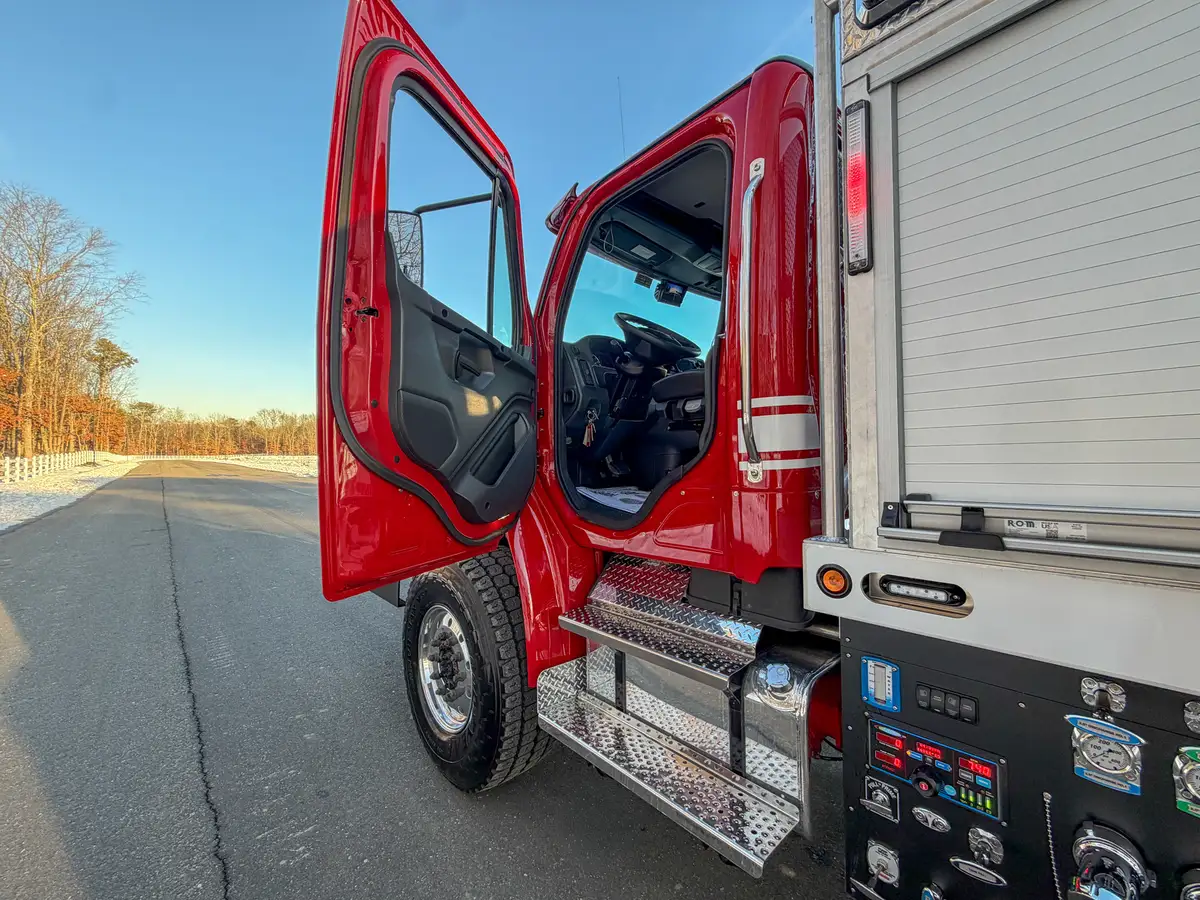 Interior view from passenger side showing seats, steering wheel, and center console controls.