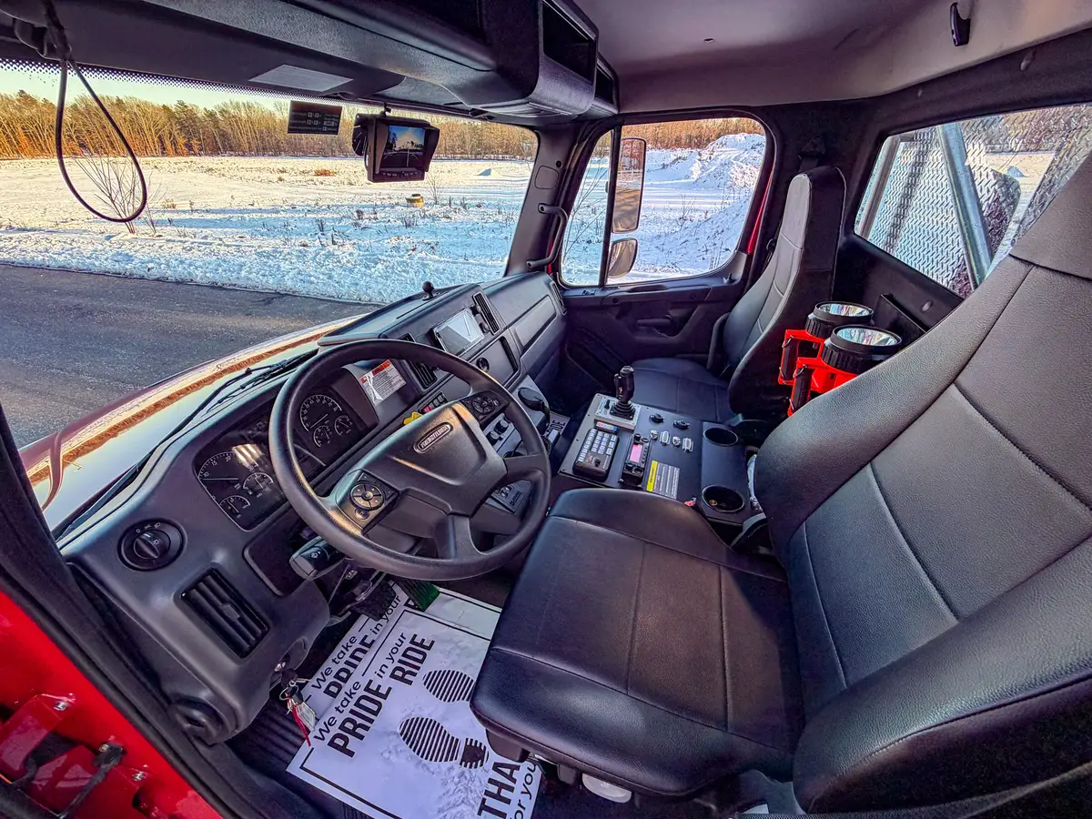 Interior cab view showing rear wall flashlights, seating, and center console panel.