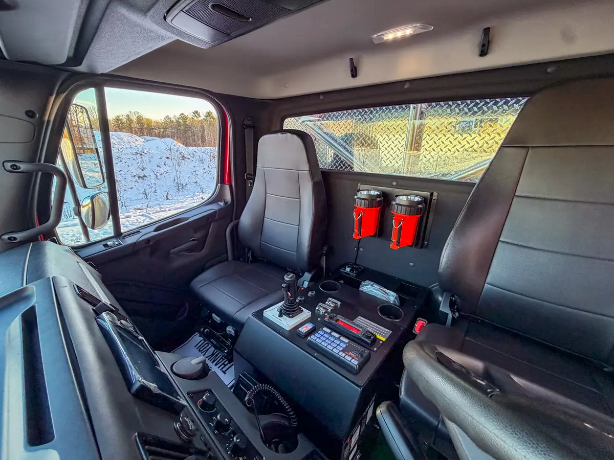 Driver-position interior view with steering wheel, gauges, and dash controls.
