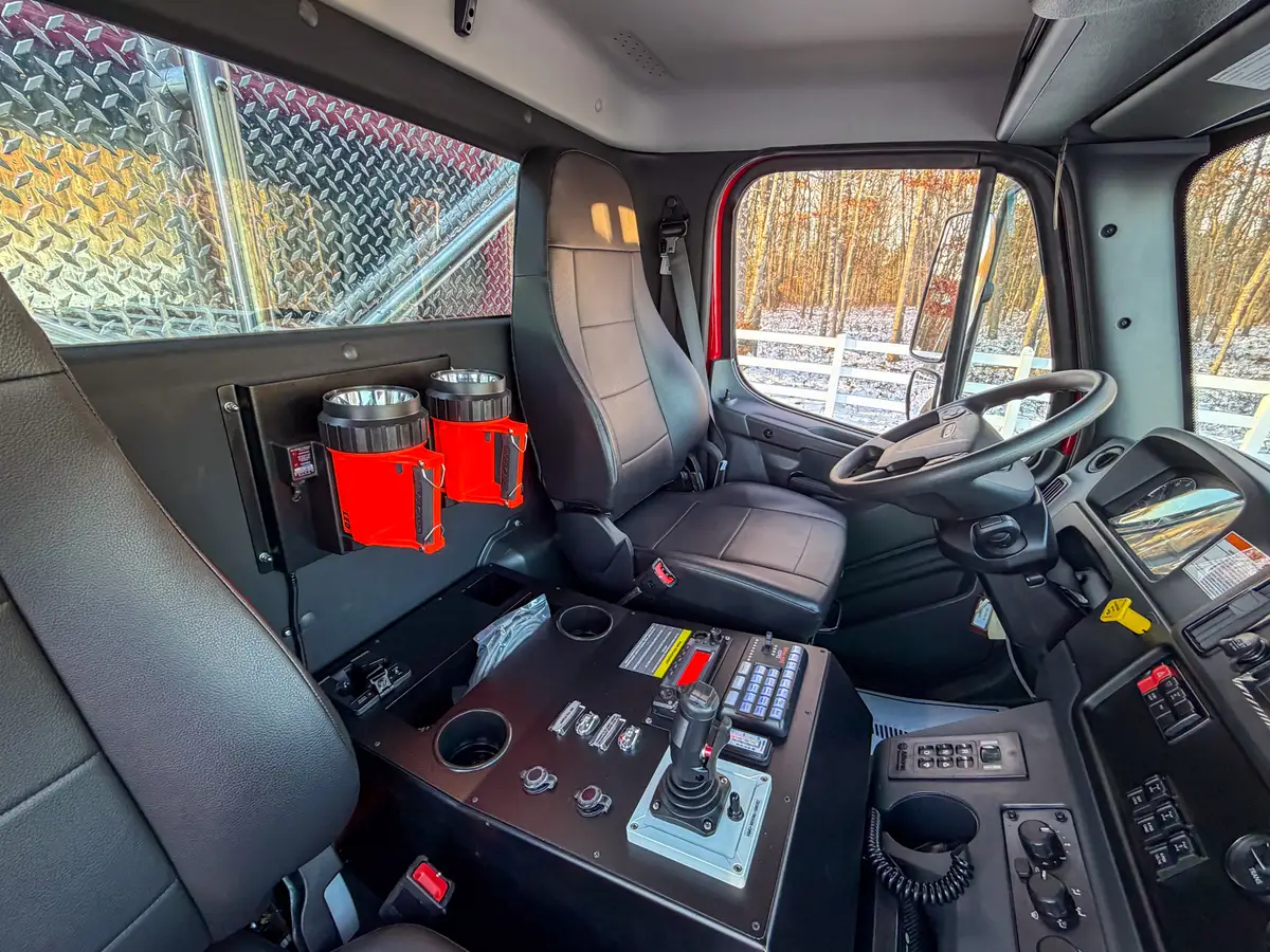 Close-up of center console controls and joystick between the seats.