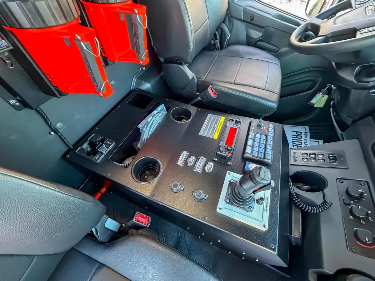 Close-up of center console warning labels, switches, and cup holders.