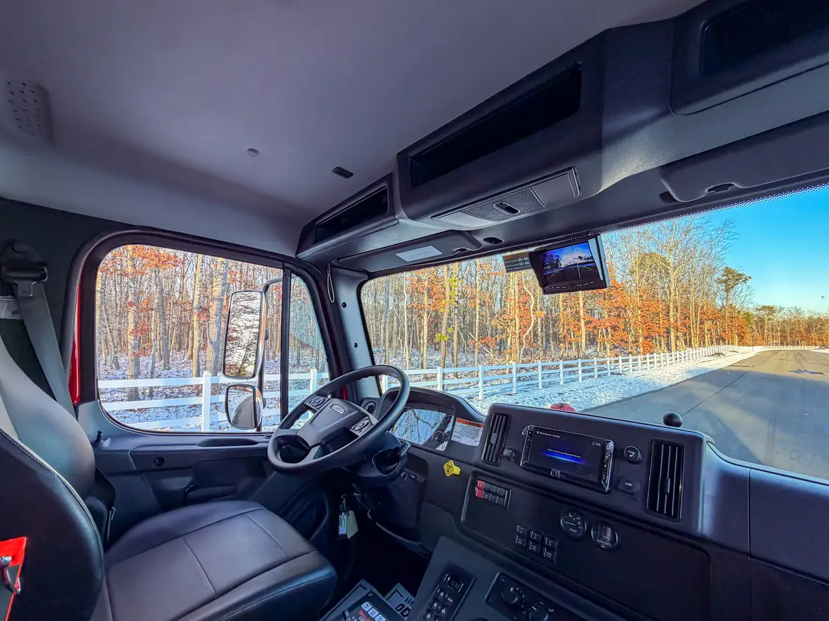 Interior cab view from passenger side showing dash, steering wheel, and overhead storage.