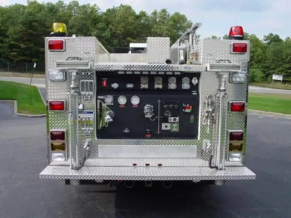 Exterior view of small fire truck showing cab, body compartments, and wheel/tire area.