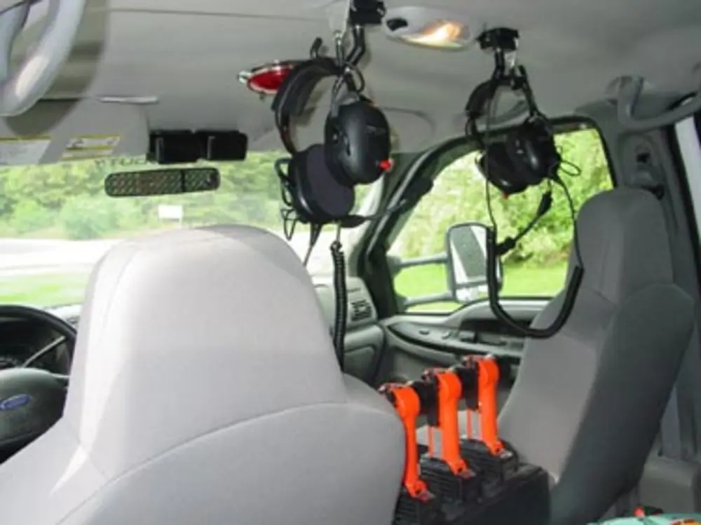 Exterior view of small fire truck showing cab, body compartments, and wheel/tire area.