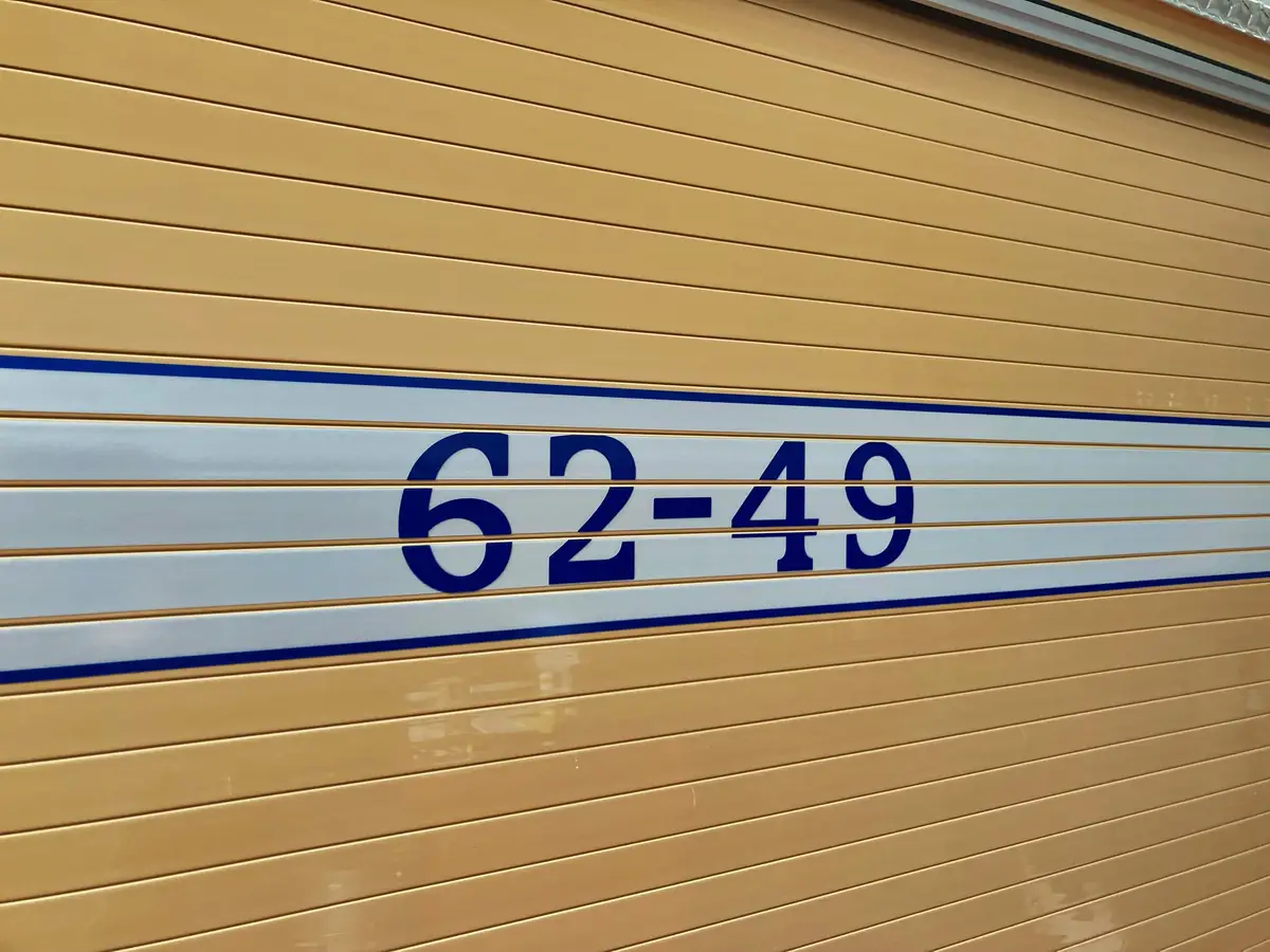 Roll-up compartment door close-up showing unit number lettering