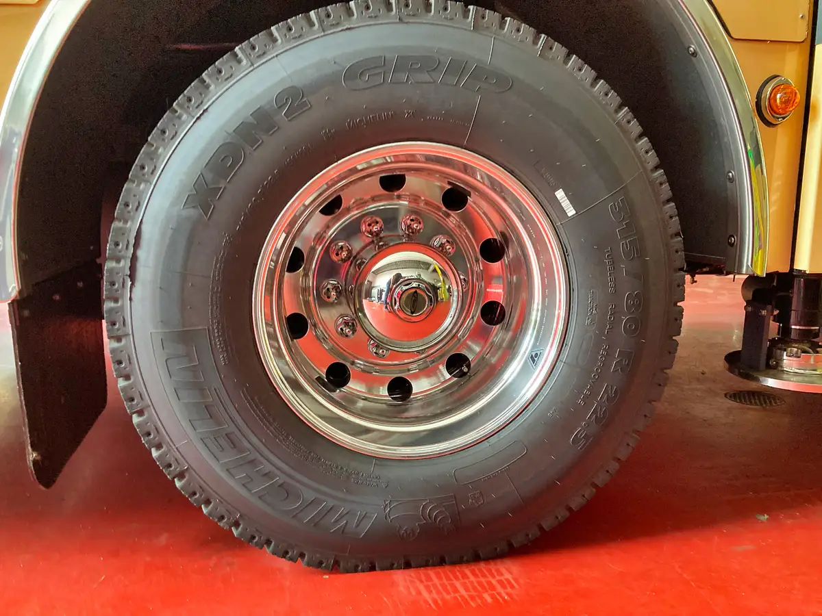 Front wheel and tire close-up showing polished rim and lug hardware