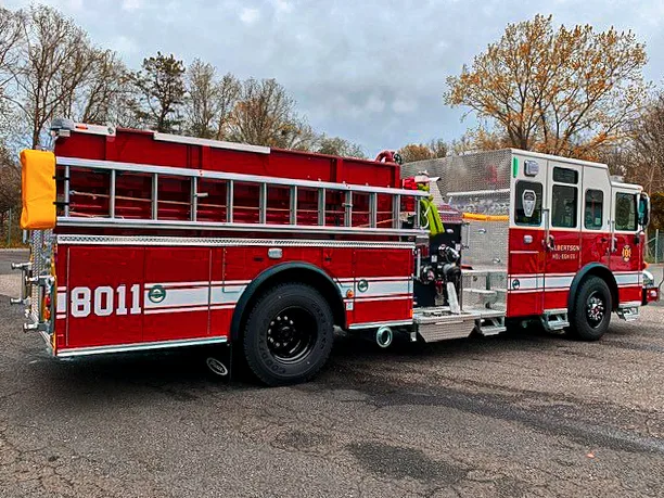 Passenger-side rear three-quarter view showing side hosebed rails and rear wheel area