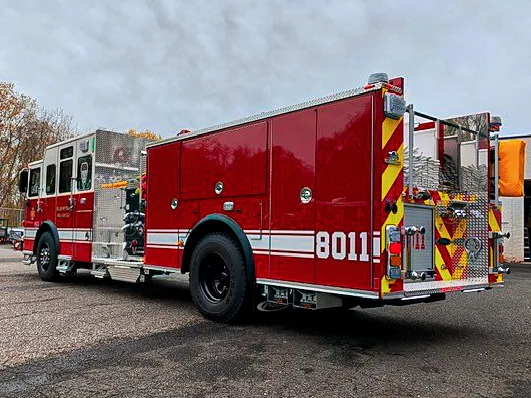 Rear-right exterior view showing chevron striping, rear body panel, and side compartments