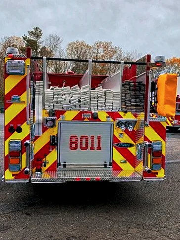 Rear view showing chevron striping, rear door panel, and upper hosebed area