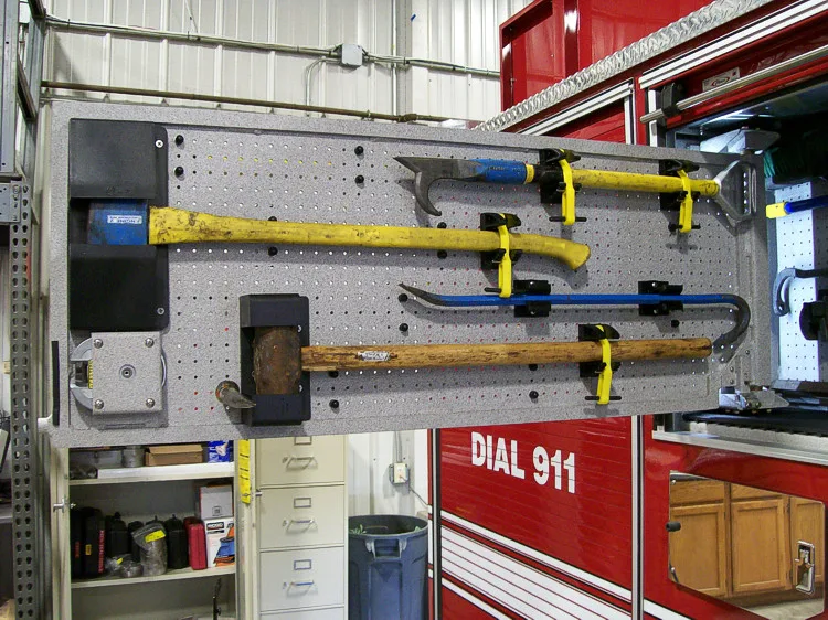 Open side compartment showing mounted long tools and lower equipment tray