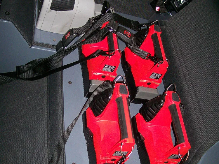 Cab interior close-up showing hanging red restraint straps by seat area