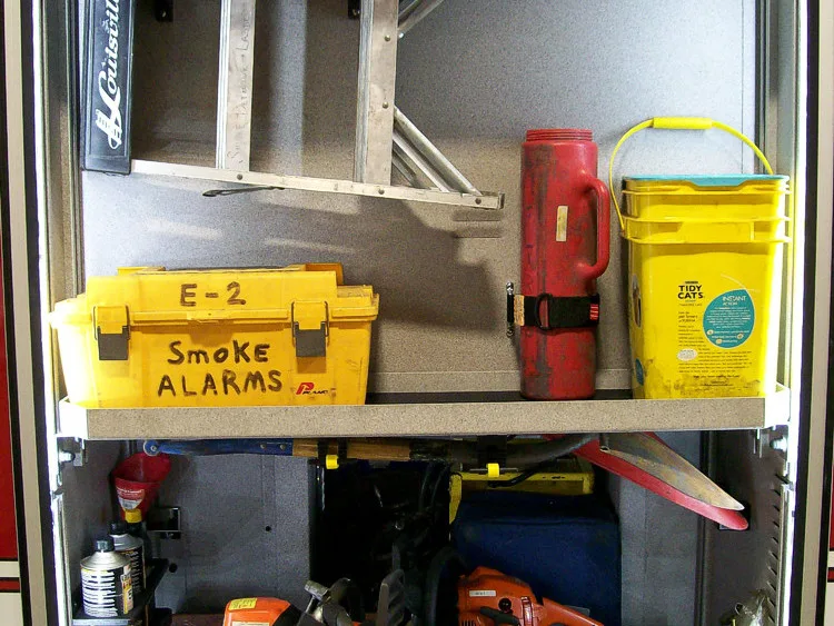 Open side compartment showing bins, ladder sections, and cooler storage