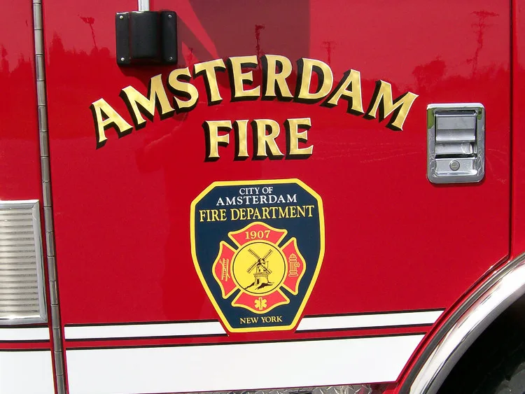 Cab side close-up showing department script and crest on red paint